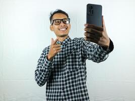 retrato de asiático hombre participación móvil teléfono con cara expresión sonriente a cámara. foto