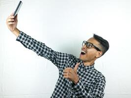 Portrait of asian man holding mobile phone with face expression smiling at camera. photo