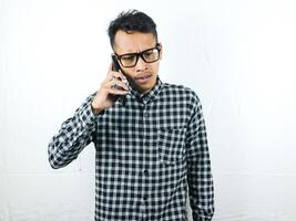 Portrait of asian man talking on phone with angry face expression. photo