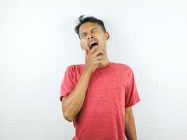 Tired asian man with yawn face expression, sleepy and back pain on white background photo