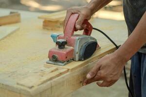 Close up of sanding a wood with orbital sander at workshop photo