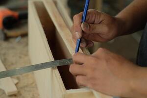 Carpenter working in workshop. carpenter measuring using pencil and ruler. photo