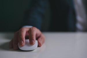 Close up of hand using on white mouse and clicking on office table photo