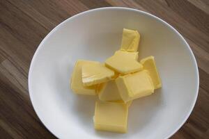 Butter slices are placed on a plate, Cut butter into cubes for baking cake photo