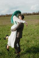 un barbado novio y un niña con verde pelo danza y giro foto