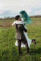 a bearded groom and a girl with green hair dance and twirl photo