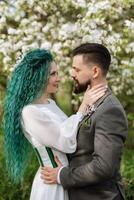 a bearded groom and a girl with green hair are walking photo