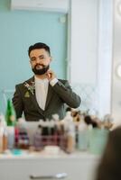 portrait of smiling groom with beard in gray color suit photo