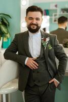 portrait of smiling groom with beard in gray color suit photo