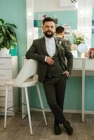 retrato de sonriente novio con barba en gris color traje foto