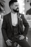 portrait of smiling groom with beard in gray color suit photo