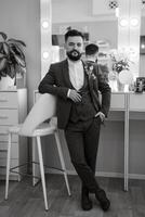 portrait of smiling groom with beard in gray color suit photo