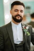 portrait of smiling groom with beard in gray color suit photo