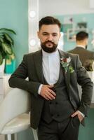 retrato de sonriente novio con barba en gris color traje foto