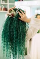 portrait of a bride with green curly hair in the beauty room photo