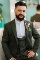 portrait of smiling groom with beard in gray color suit photo
