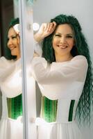 portrait of a bride with green curly hair in the beauty room photo