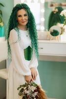 portrait of a bride with green curly hair in the beauty room photo