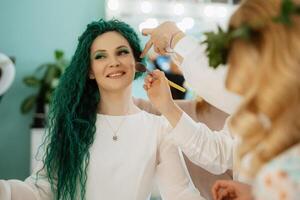 portrait of a bride with green curly hair in the beauty room photo