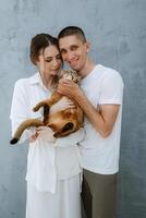 young couple guy and girl in a bright room playing with pets photo