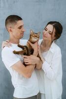 young couple guy and girl in a bright room playing with pets photo