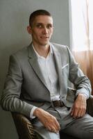 retrato de un novio en un gris tartán traje con un Corbata en un ligero bar foto