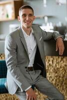 portrait of a groom in a gray plaid suit with a tie in a light bar photo