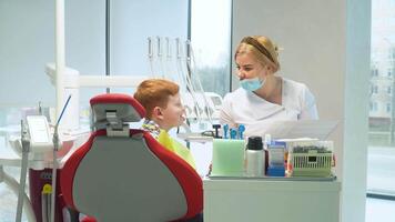 hembra dentista escribe en un médico tarjeta el síntomas de un chico paciente. seguro odontología video
