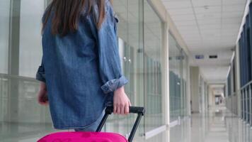 liten flicka promenader med en resväska i flygplats terminal video