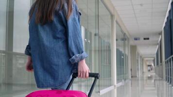 peu fille des promenades avec une valise dans aéroport Terminal video