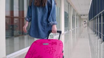 weinig meisje loopt met een koffer in luchthaven terminal laat voor vlucht video