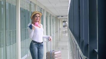 Beautiful woman with a passport at the airport awaits the arrival of the plane video