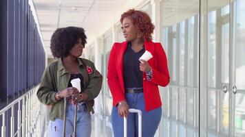 dois africano americano amigas estão esperando para embarque e partindo às a aeroporto. meninas beber café às a aeroporto video