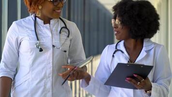 In the hospital, busy african american doctors talk, while walking through the building. New modern fully functional medical facility video