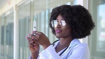 Medical african american doctor preparing syringe for injection. Close up of african american doctor in hospital. Covid-19 vaccine video