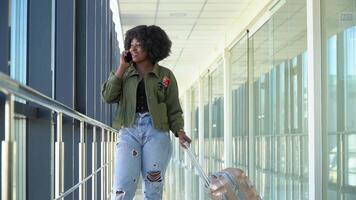 africano americano menina estão esperando para embarque e partindo às a aeroporto e falando em a telefone video