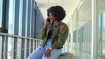 Afrikaanse Amerikaans meisje zijn aan het wachten naar instappen en vertrek Bij de luchthaven en pratend Aan de telefoon video