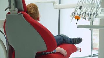 Little boy at reception at dentist in dental chair that rises. Pediatric dentistry video