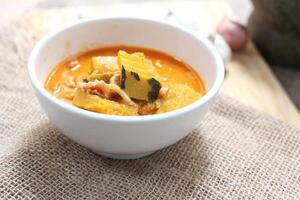Red Curry Pumpkin with Chicken served on wooden table, delicious Thai food popular in Thailand, Asia food. photo