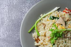 Fried rice with pork and vegetables in a plate on the table photo