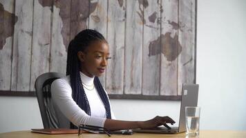 Beautiful african american student uses laptop video