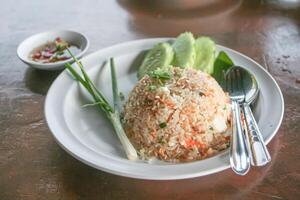 Fried rice thai style on white dish with spoon and fork photo