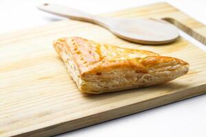 Chicken Pie or Baklava on wooden board and wood spoon on white background photo