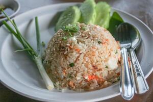 Fried rice thai style on white dish with spoon and fork photo