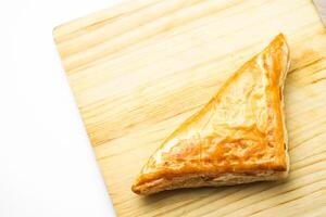 Chicken Pie or Baklava on wooden board and wood spoon on white background photo