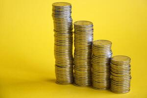 Several columns of coins on a yellow background. photo