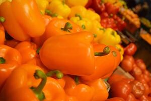 Fresh yellow and red organic bell peppers on the counter in the supermarket. photo