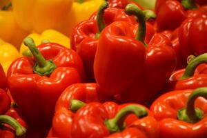 Fresh red and yellow organic bell peppers on the counter in the supermarket. photo