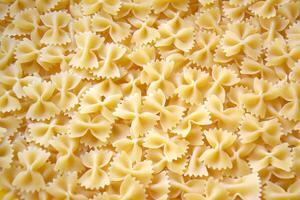 A lot of pasta in the shape of a butterfly on the table as a background. photo