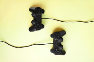 Two joystick gaming controlle on yellow background. photo